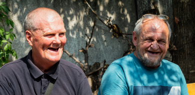 Image shows two men laughing.
